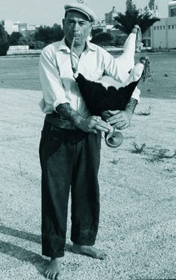 Toni Cachia (I -Hammarun) of Naxxar playing his calf‑skin żaqq in December 1972.  Note the rubber tubing used as a blowpipe and the way the chanter is held almost horizontally.